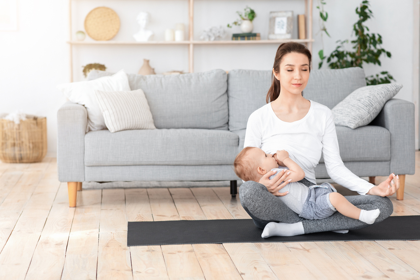 Coping With Motherhood Stress. Young Mom Breastfeeding Baby And Meditating At Home